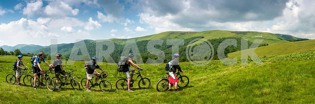 Tourists with backpacks on the bike in the Carpathian Mountains