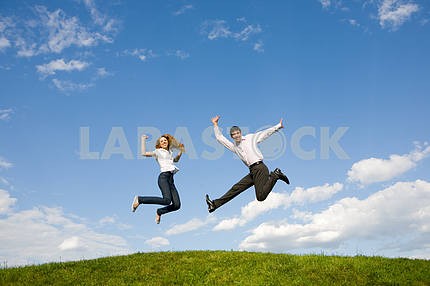 Счастливая пара улыбаясь прыжки в голубое небо