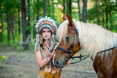 Красивая девушка в костюме индейской женщины в плотва с лошадью