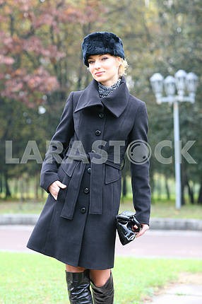 Красивая блондинка на открытом воздухе в пальто и шляпу
