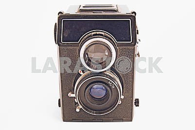 Старый советский пленочный фотоаппарат с объективом на белом фоне крупным планом