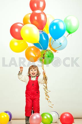 Маленькая девочка в красном прыжки с воздушными шарами