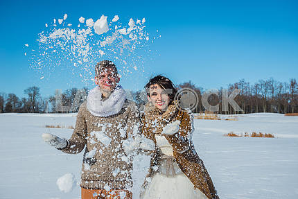Молодая пара свадьба, играя в снегу в Солнечный зимний день. Свадьба в деревенском стиле. Милая девушка в коротком свадебном белом платье, голубое небо на заднем плане. Браун свадебный стиль