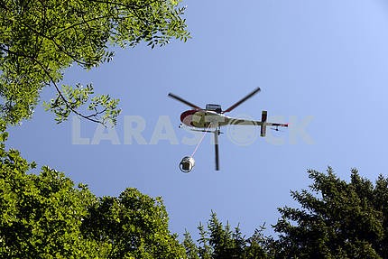 Вертолет несет груз в Альпах
