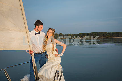 Медовый месяц парусный спорт - стильный молодой невесты и жениха, сидя на носу борту парусной яхты