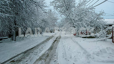Заснеженная сельская улица, красивый зимний пейзаж, облачно