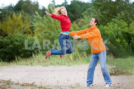 Счастливый молодая пара - прыжки на зеленой дерева