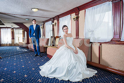 Прекрасная свадебная пара. Невеста в белом свадебном платье счастливо улыбается. Жених в голубом костюме. влюбленная пара
