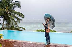 Девушка стоит с зонтом в руках на фоне океана