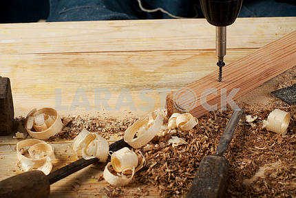 Инструменты для кожанного ремесла на деревянном фоне. Рабочий стол мастера по коже. Кусок шкуры и рабочие инструменты ручной работы на рабочем столе