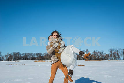 Молодая пара свадьба, играя в снегу в Солнечный зимний день. Свадьба в деревенском стиле. Милая девушка в коротком свадебном белом платье, голубое небо на заднем плане. Браун свадебный стиль