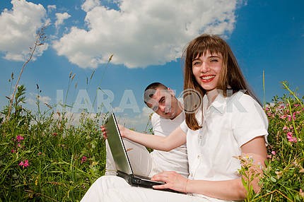 Повседневная счастливая пара на ноутбуке на открытом воздухе компьютере