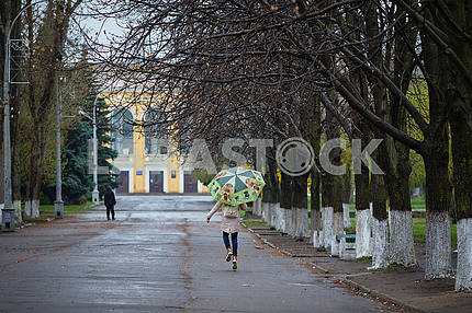 Девочка бежит под зонтиком