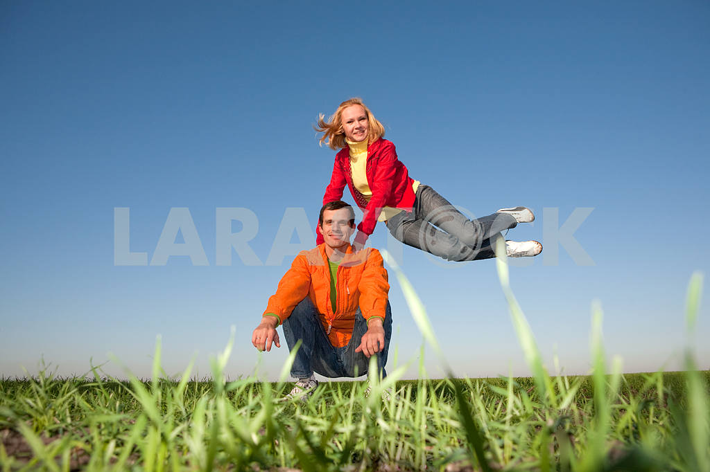 Счастливая пара улыбаясь прыжки в голубое небо — Изображение 6811