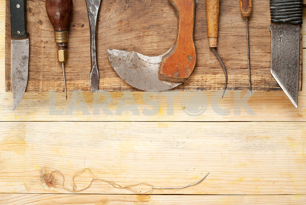Leather craft tools on a wooden background. Leather craftmans work desk . Piece of hide and working handmade tools on a work table — Image 46232