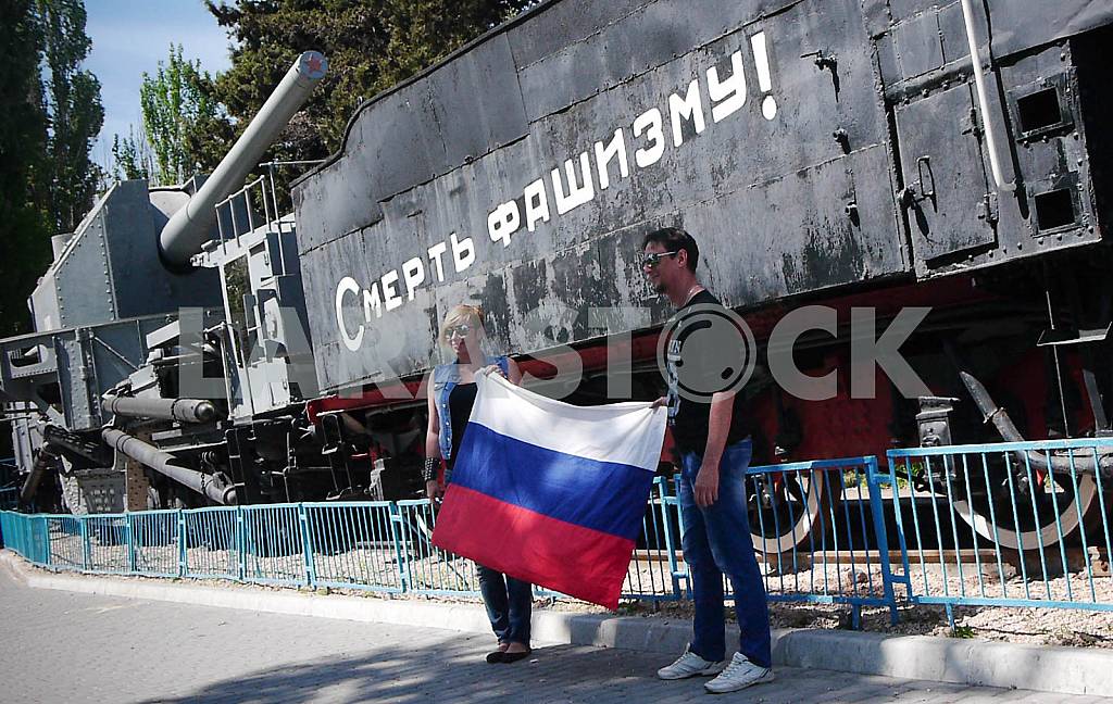 People posing with the Russian flag against the background of the artillery train "Zheleznyakov" in Sevastopol. — Image 38533