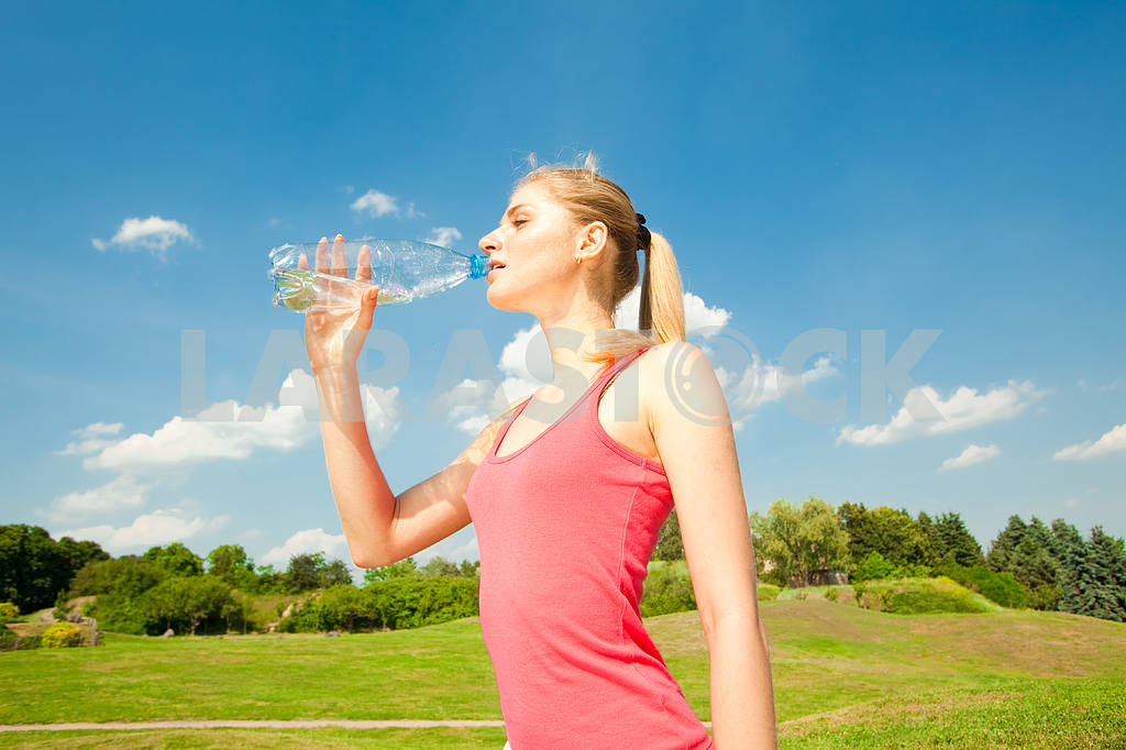 Красивая девушка питьевой воды против голубого неба — Изображение 5893