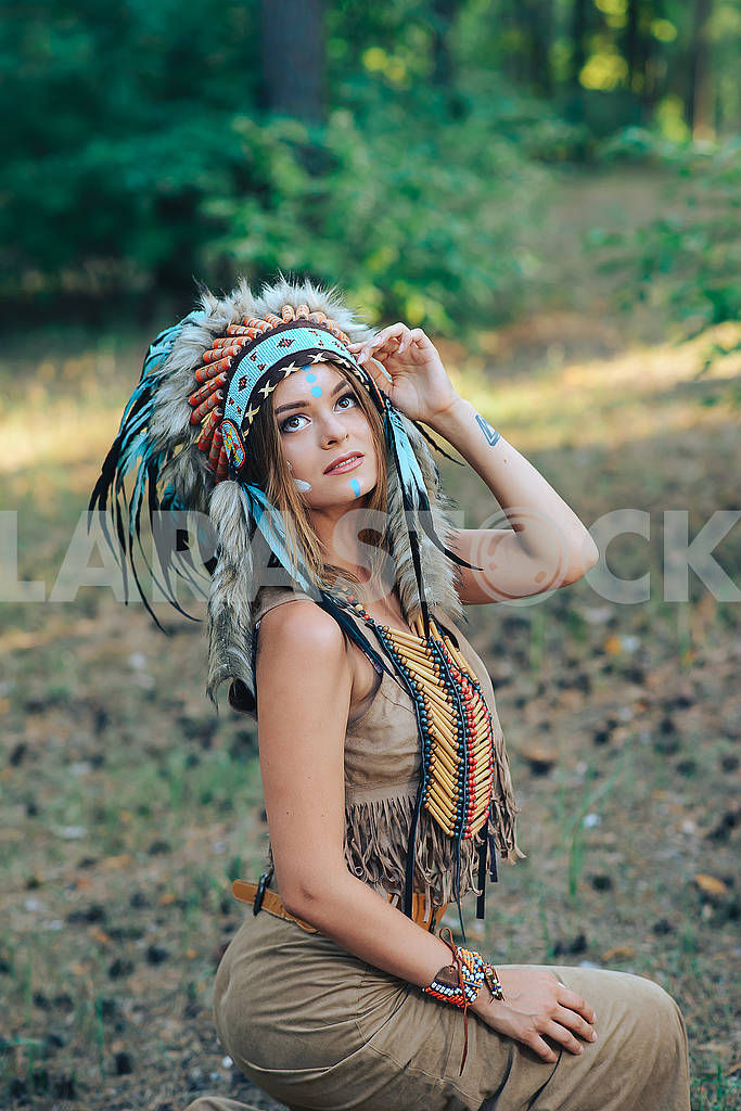 Young woman dressed in an Indian style in the woods Portrait of a young lady in the Indian roach Beautiful girl in a suit of the American Indian — Image 62054