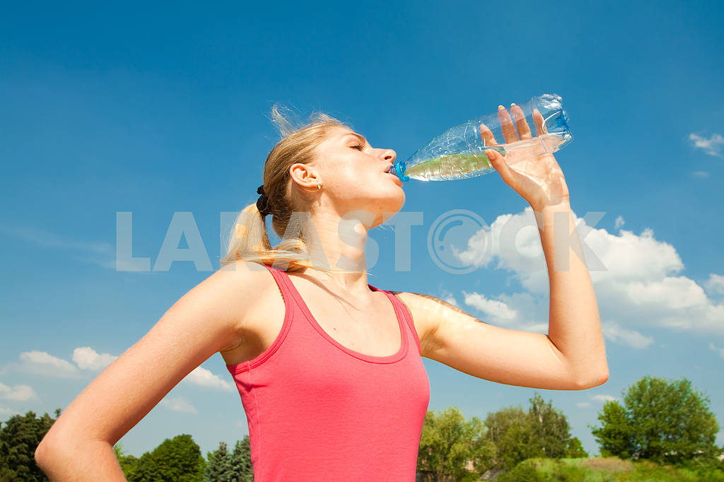 Красивая девушка питьевой воды против голубого неба — Изображение 5894
