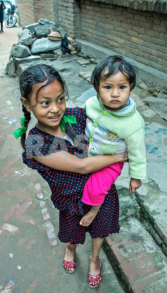 Маленькая девочка несет свою сестру на руках — Изображение 54036
