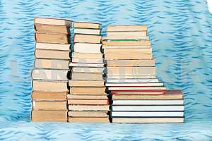 Old and used hardback books or text books on wooden table. Books and reading are essential for self improvement, gaining knowledge and success in our careers, business and personal lives. Copy space