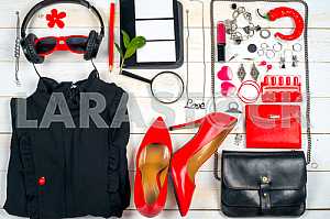 Women clothing set and accessories on white wooden background.