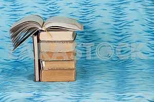Old and used hardback books or text books on wooden table. Books and reading are essential for self improvement, gaining knowledge and success in our careers, business and personal lives. Copy space