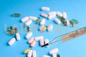 Many pills and tablets isolated on light blue background