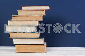 Stack of hardback books on wooden table. Back to school. Copy space