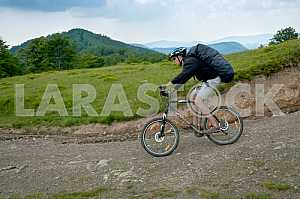 Tourists with backpacks on the bike in the Carpathian Mountains