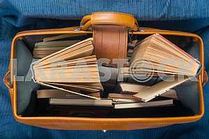 Открытая книга, стопка книг в твердом переплете на деревянном столе. Обратно в школу. Копирование пространства