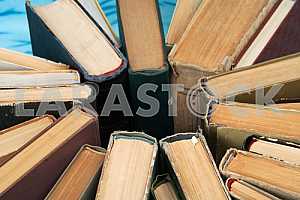 Old and used hardback books or text books on wooden table. Books and reading are essential for self improvement, gaining knowledge and success in our careers, business and personal lives. Copy space