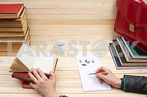 On a wooden table books, documents, calculator, red briefcase.