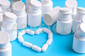 Many pills and tablets isolated on light blue background