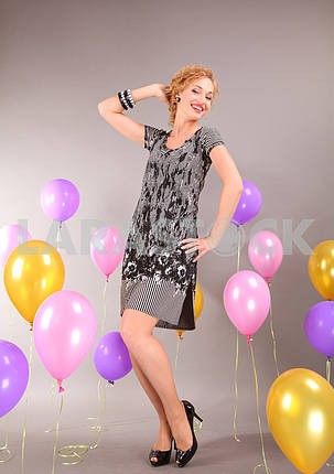 Beautiful young girl in light dress on background balloons