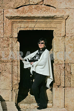A woman in a window opening on the ruins of the ancient city of Jarash