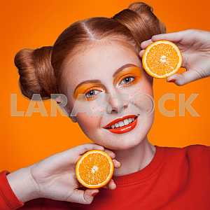 Young beautiful fashion model with orange. studio shot.