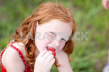 Девушка , которая ест клубнику . Мягкий фокус. Сосредоточьтесь на глаза .