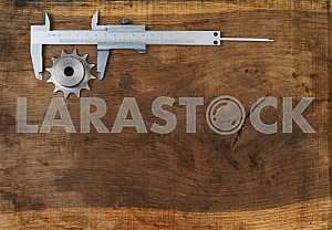 Different construction tools on a wooden background - screwdriver, caliper.