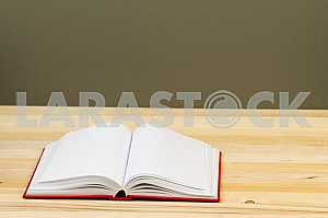 Открытая книга, стопка книг в твердом переплете на деревянном столе. Обратно в школу. Копирование пространства