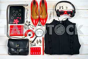 Women clothing set and accessories on white wooden background.