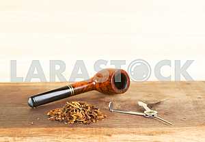 Smoking pipe on a wooden table. Aroma. Copy space