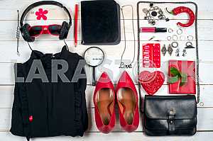 Women clothing set and accessories on white wooden background.