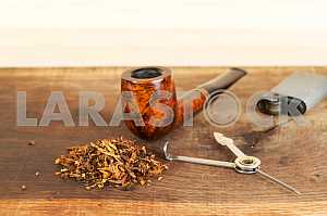 Smoking pipe on a wooden table. Aroma. Copy space