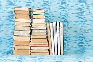 Old and used hardback books or text books on wooden table. Books and reading are essential for self improvement, gaining knowledge and success in our careers, business and personal lives. Copy space