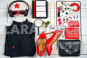 Women clothing set and accessories on white wooden background.