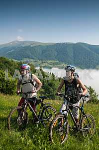 Tourists with backpacks on the bike in the Carpathian Mountains