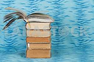 Old and used hardback books or text books on wooden table. Books and reading are essential for self improvement, gaining knowledge and success in our careers, business and personal lives. Copy space