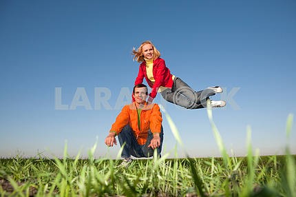 Happy smiling couple  jumping in blue sky