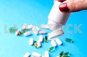 Many pills and tablets isolated on light blue background